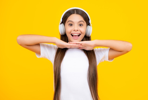 Stylish teenage girl listening to music with headphones kids lifestyle concept wireless earphones excited teenager glad amazed and overjoyed emotions