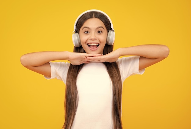 Stylish teenage girl listening to music with headphones Kids lifestyle concept Wireless earphones Excited teenager glad amazed and overjoyed emotions