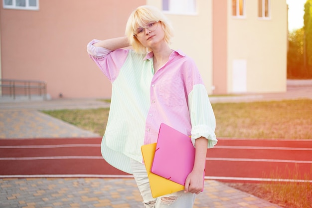 Stylish teenage girl with folders in her handsStaying near school or collegeready for education