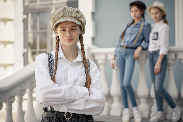 Stylish teenager girl posing against the background of her friends