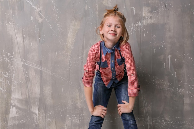 stylish teenager girl posing on grey background