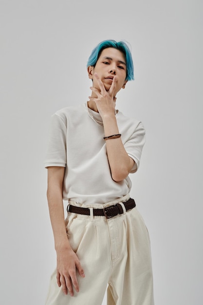 Stylish teenager with blue hair posing at camera