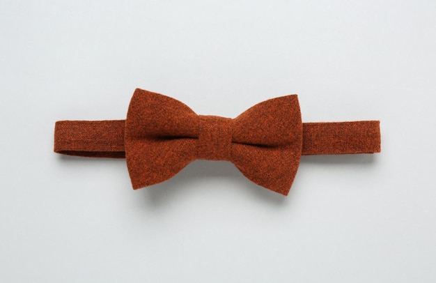 Stylish terracotta bow tie on white background top view