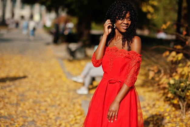 Stylish trendy afro france curly woman posed at autumn day in red dress Black african female model