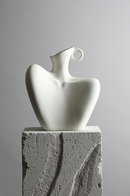 stylish vase on concrete block against light grey background