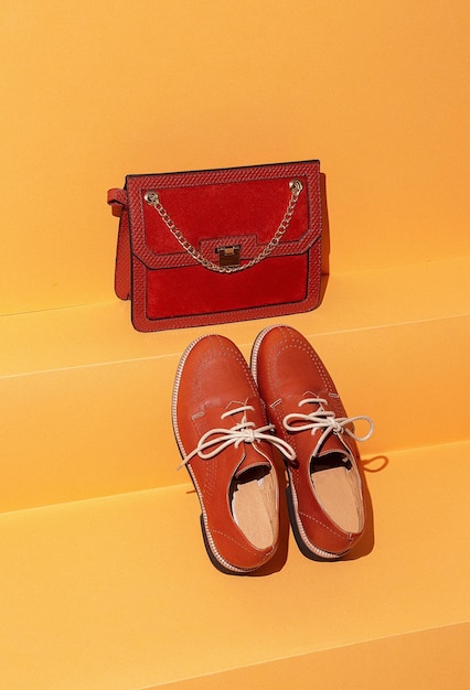 Stylish vintage bag and shoes on yellow shelf in the store space