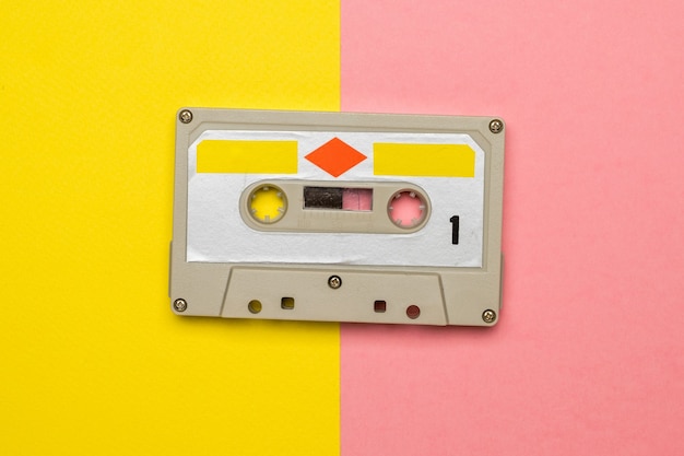 Stylish vintage tape recorder on a yellow and pink background.