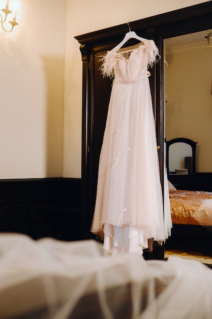 인테리어의 나무 옷걸이에 걸려 있는 세련된 웨딩 드레스