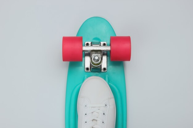 Stylish white sneakers with cruiser board on white