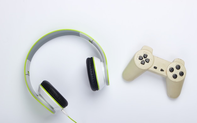 Eleganti cuffie stereo cablate con gamepad su superficie bianca