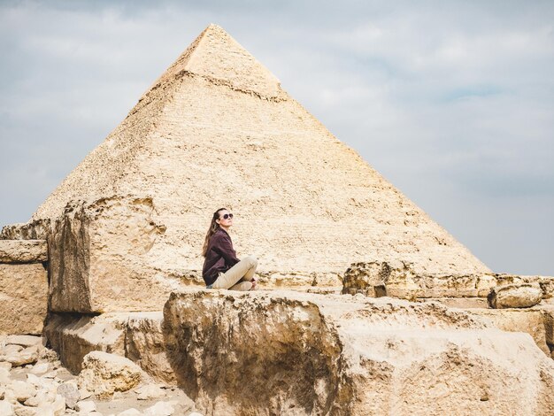 Stylish woman against the background of the Giza pyramid complex