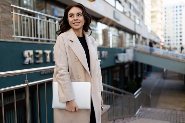 Stylish woman businessman with a laptop in his hands in no society