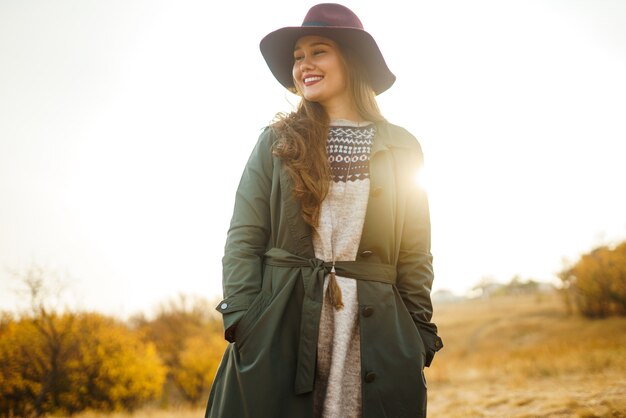 Stylish woman enjoying autumn weather in the meadow