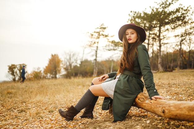 Stylish woman enjoying autumn weather in the meadow