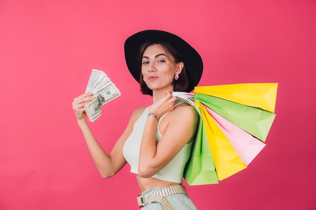 Stylish woman in hat on pink red wall