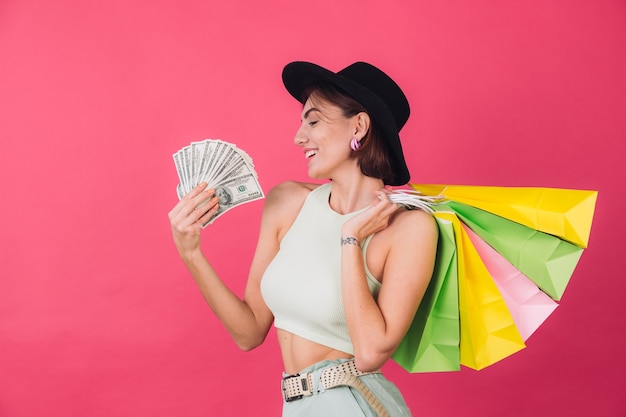 Stylish woman in hat on pink red wall