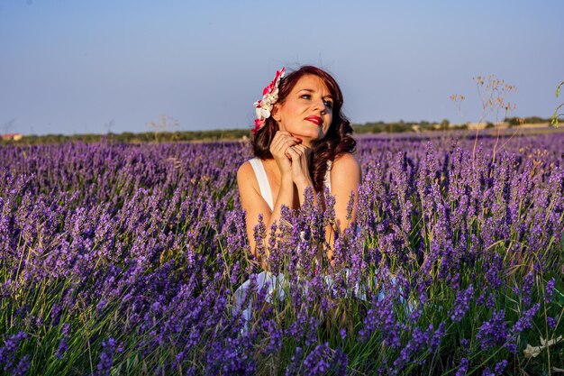 カラフルなラベンダー畑で屋外でポーズをとりながら目をそらすスタイリッシュな女性