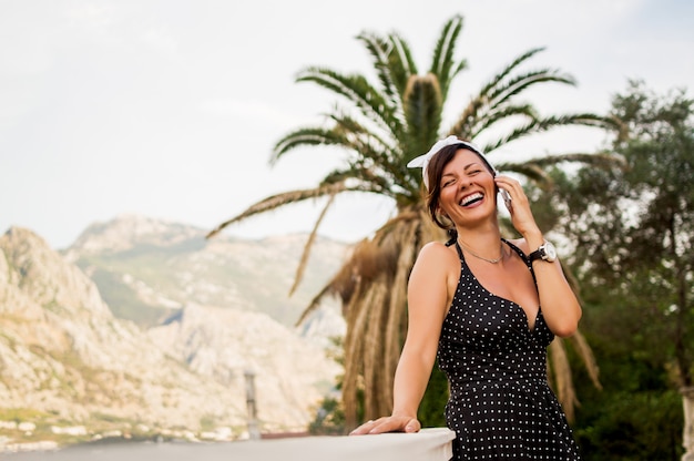 Stylish woman in summer outfit talking on phone.