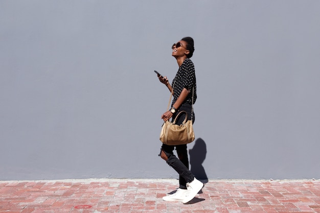 Photo stylish woman walking with bag and mobile phone