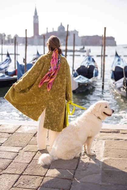 イタリアのベニスで犬と一緒に歩くスタイリッシュな女性