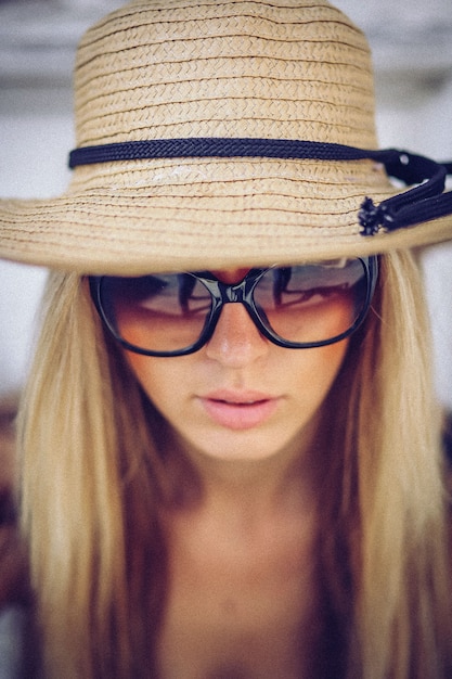 Donna alla moda in cappello bianco in piedi sulla città vecchia