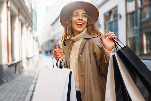 Foto una donna elegante con borse della spesa cammina per le strade della città spring style lifestyle concept