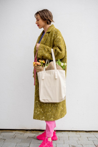 Stylish woman with tote bag on background