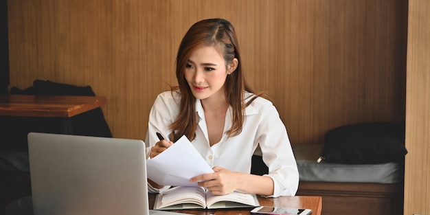 A stylish woman working on a laptop