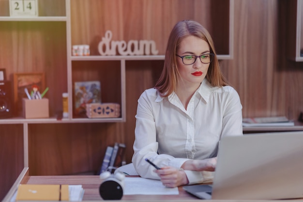 Stylish woman works at a laptop desk in a modern office