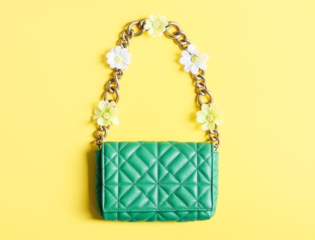 Stylish women's fashionable green quilted handbag with a large gold chain and spring flowers