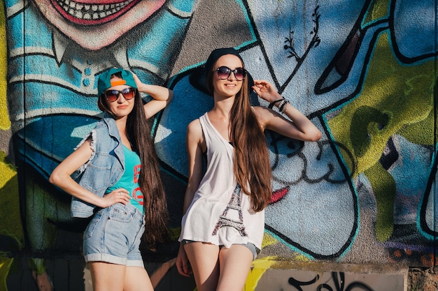 Stylish women on street with graffiti