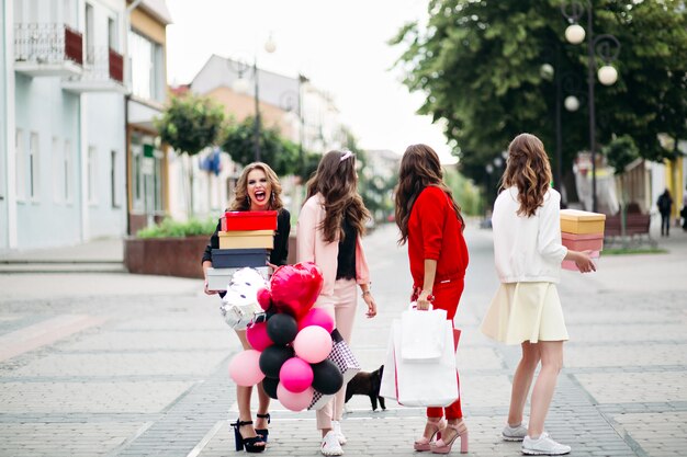 Stylish women with shopping bags in the street.