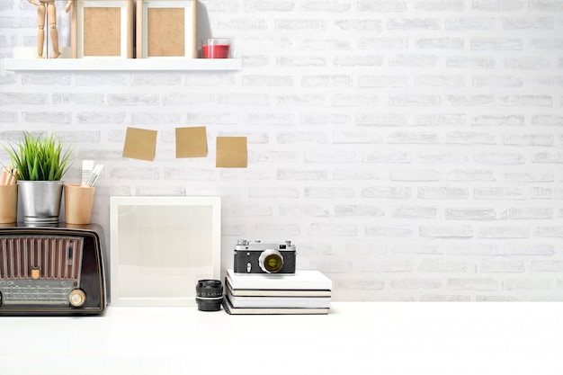 Stylish workplace desk vintage camera, blank screen tablet and gadget