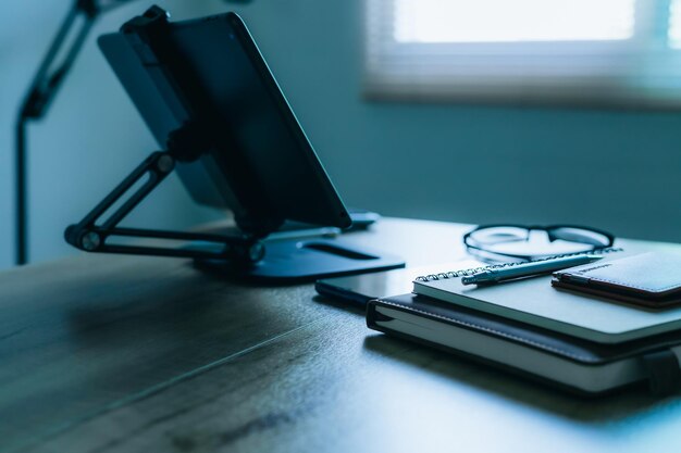 Stylish workplace with telephone and tablet PC on table in home office beautiful blue fillter