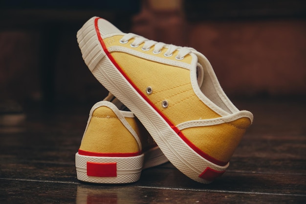 Stylish yellow sneakers on a wooden floor closeup