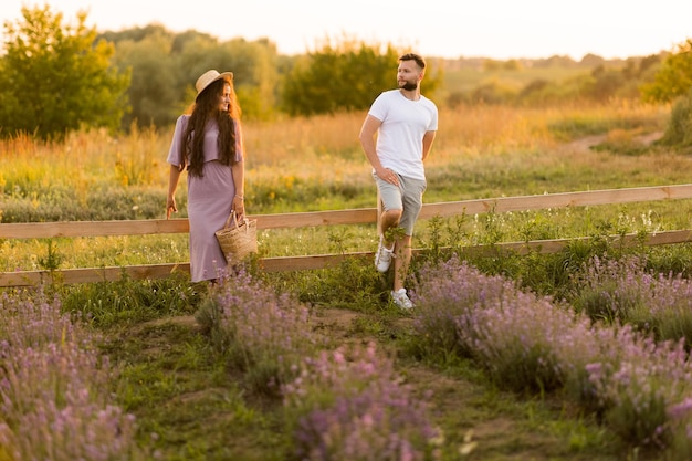 Stylish young adult couple walking at lavender field having a romantic date