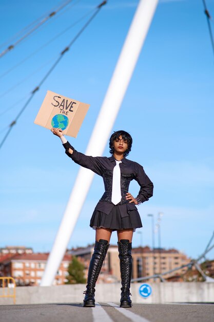 Stylish young african american woman in black with white tie\
protesting against environmental pollution.