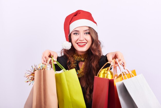 Stylish young brunette woman with colorful shopping bags