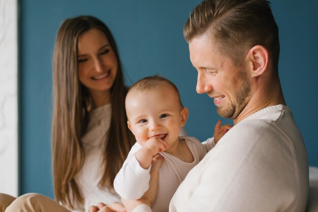 Foto una giovane famiglia elegante tiene in braccio un bambino