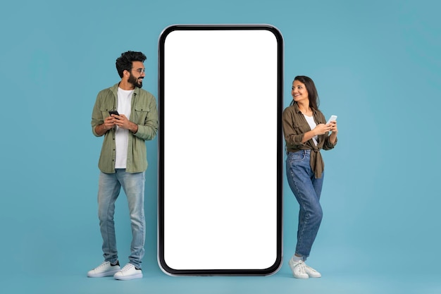 Stylish young indian man and woman using phones