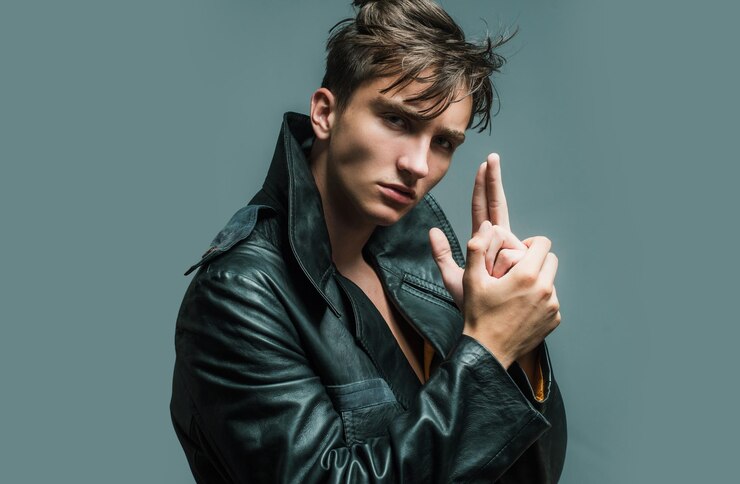 Photo stylish young man against a grey background with finger gun gesture