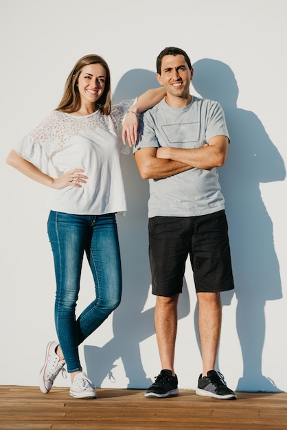 A stylish young man is holding hands with his brunette girlfriend in the port