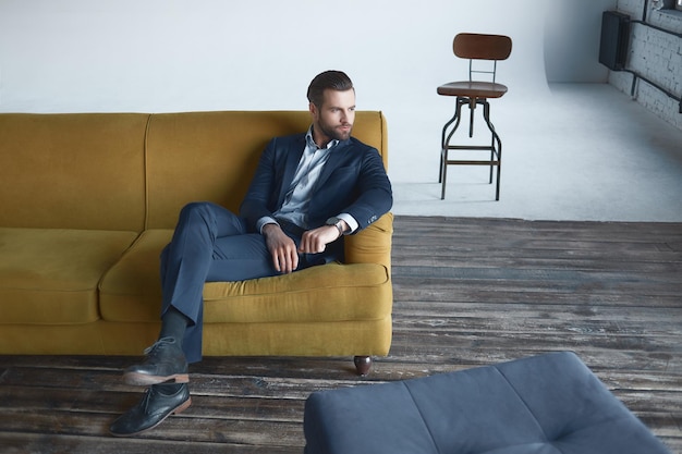 Stylish young man in a suit and bow tie. Business style. Fashionable image. Evening dress. Sexy man standing and looking at the camera. Fashion look