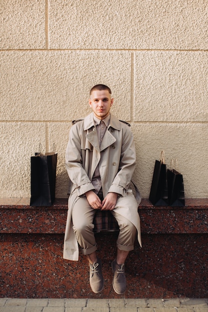 A stylish young man with bags after successful shopping on Black Friday