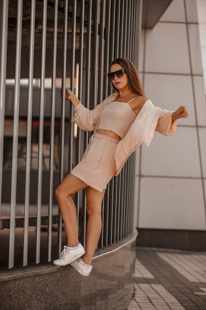 Photo a stylish young pretty woman in beige clothes