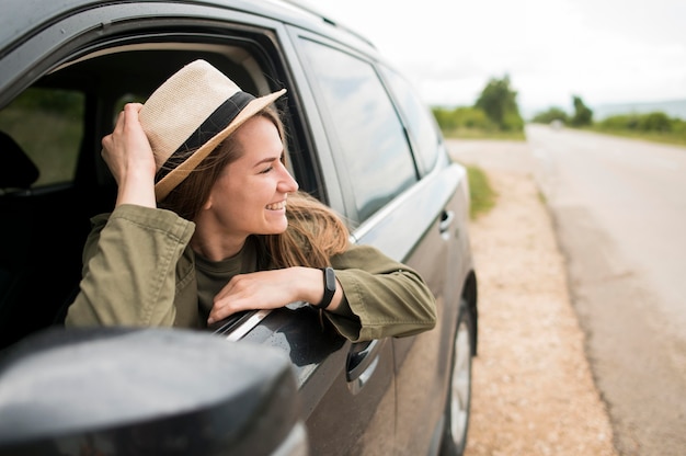 Foto giovane viaggiatore alla moda che gode del giro con l'automobile