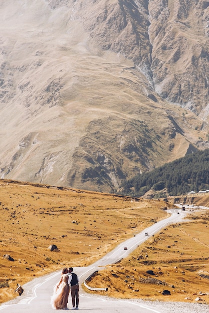 Stylish young wedding couple has fun posing in beautiful Georgian mountains 