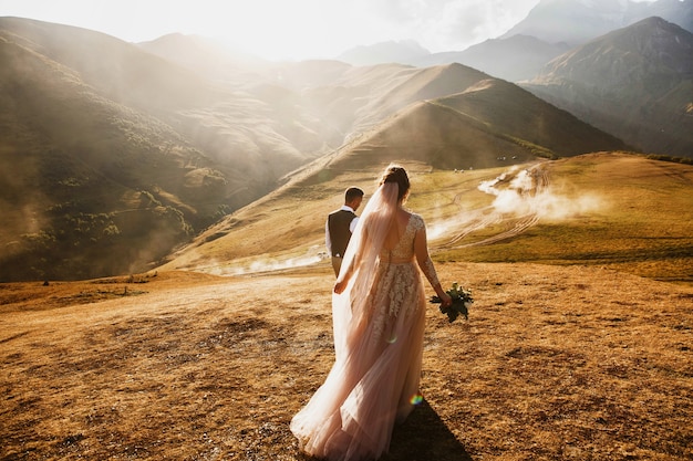 Stylish young wedding couple has fun posing in beautiful Georgian mountains