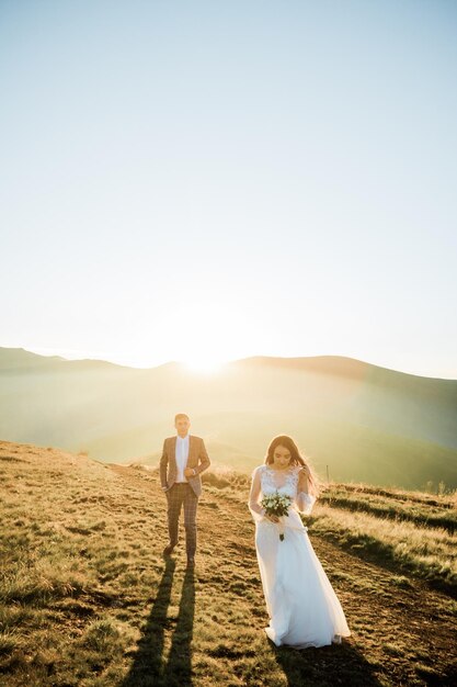 Стильная молодая свадебная пара весело позирует в красивых горах