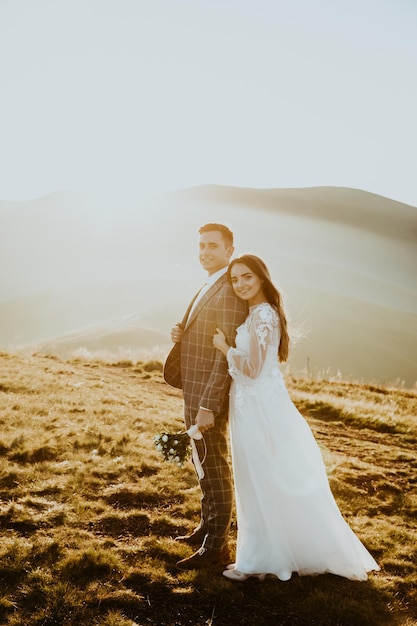Stylish young wedding couple has fun posing in beautiful mountains